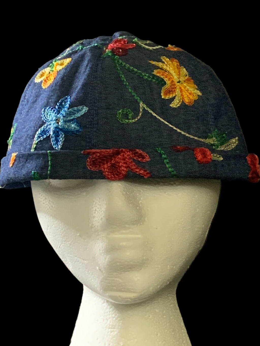 Embroidered fabric with floral designs with a black background front view. 