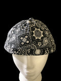Black paisley fabric roll cap with black botton on top. Front view 