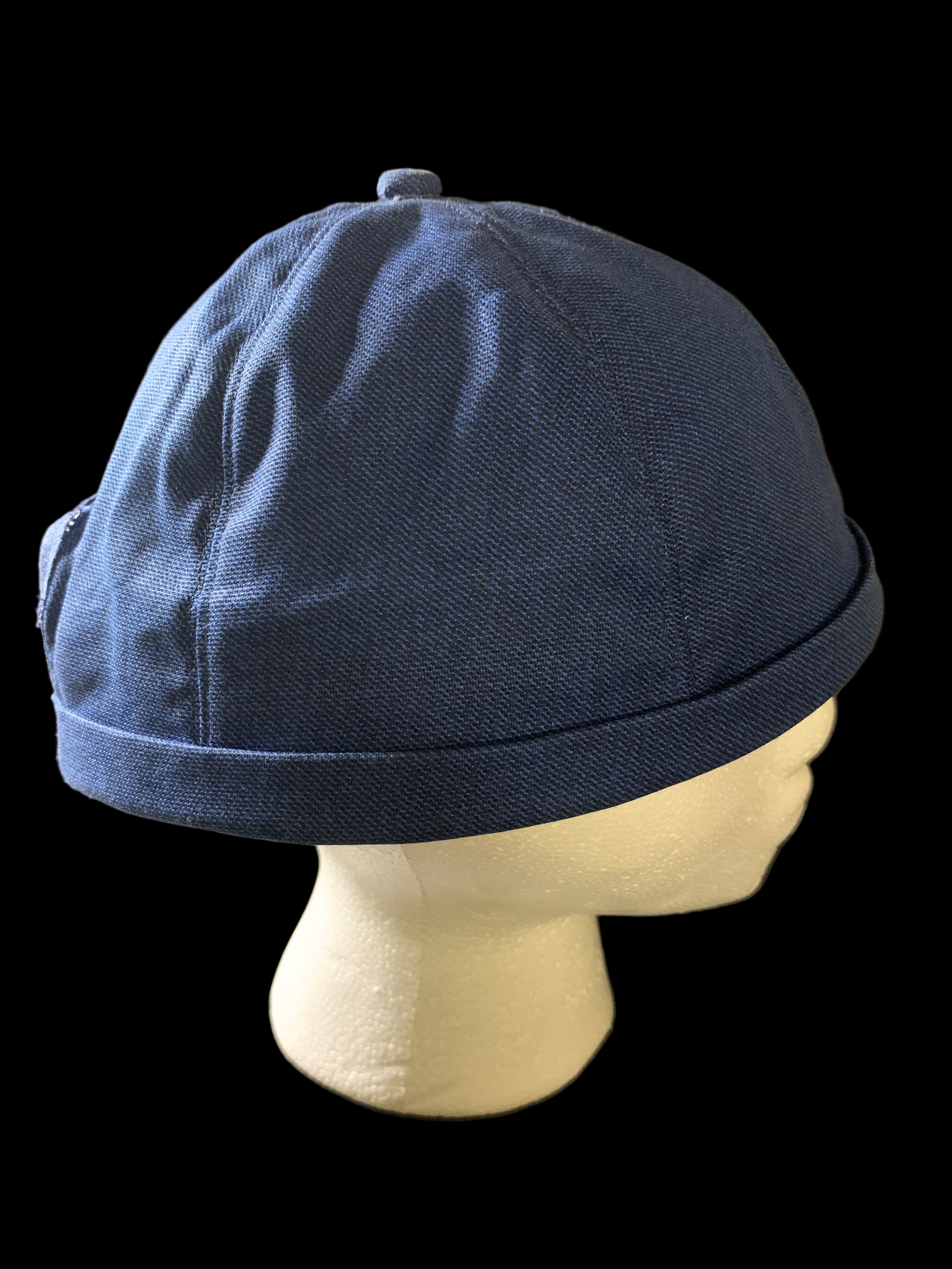 Snap back roll cap with a blue botton. Blue Jean fabric side view 