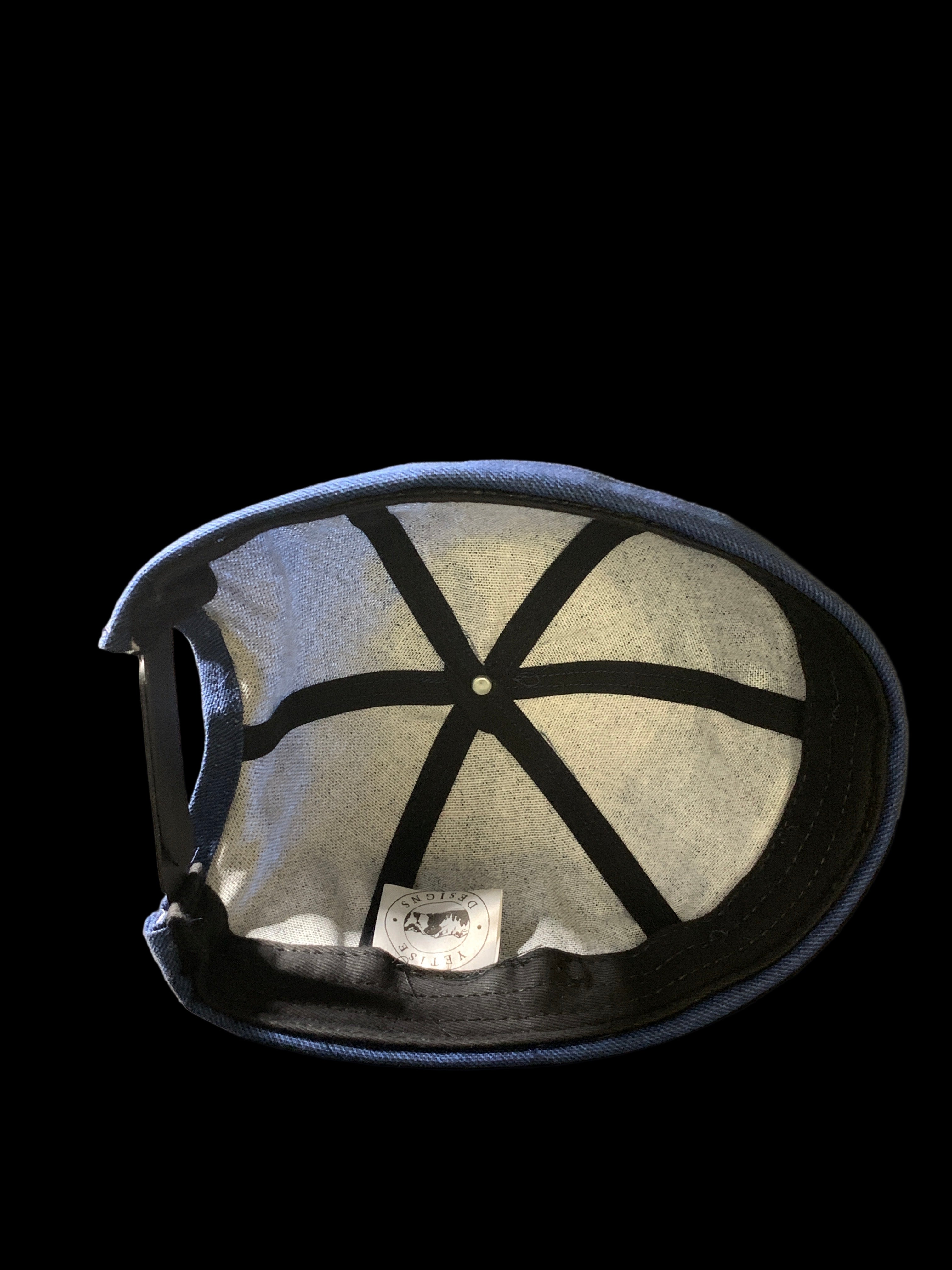  Inside of Snap back roll cap hat with black trimmings and sweatband. 