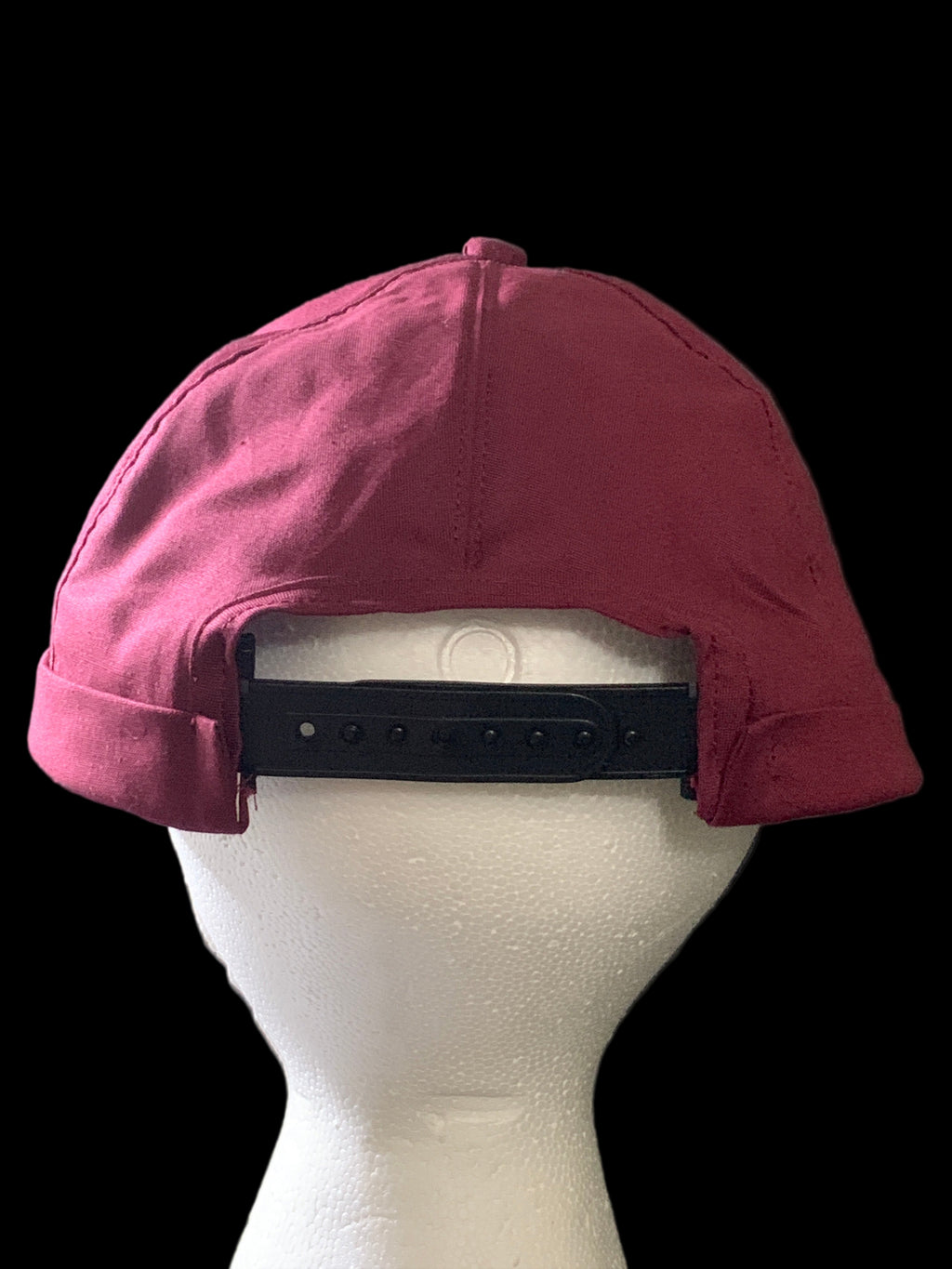 Backside  picture of  burgundy hat with button and black snaps.