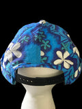  Polynesian Blue floral-patterned hat with black snaps and black background. 